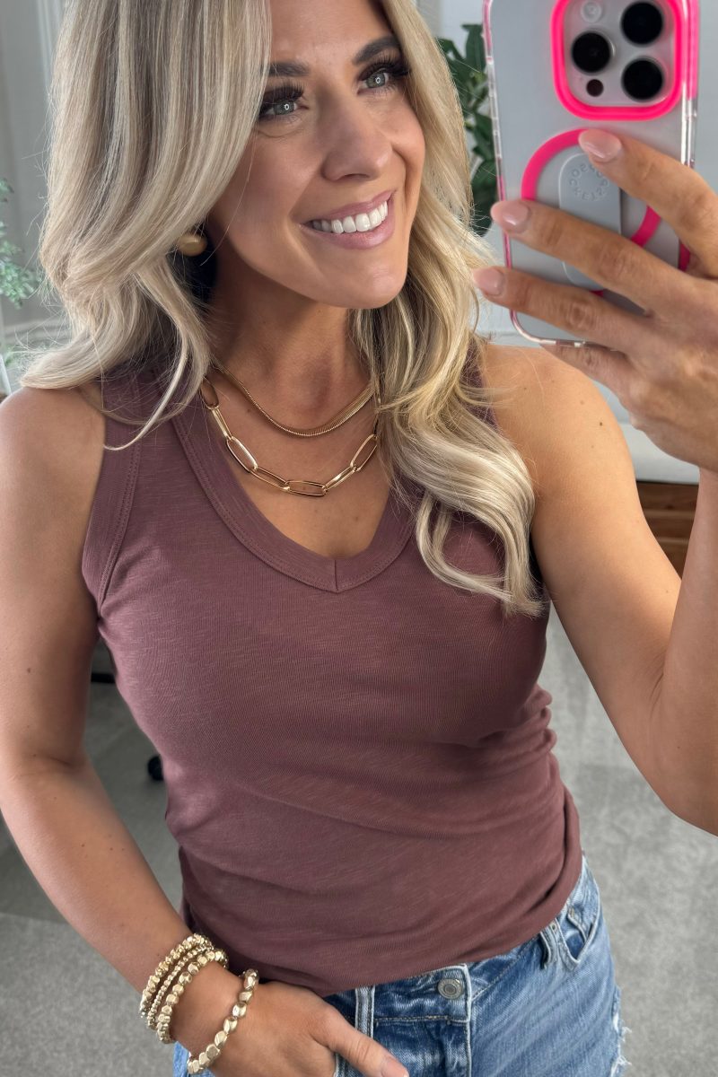 BLONDE WOMAN WEARING A BASIC DYED COTTON V-NECK RIBBED TANK WITH SCOOP V-NECKLINE.