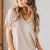 women modeling a creamy neutral short sleeve corded v neck top